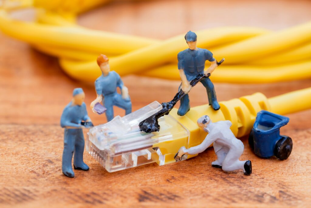 Close up miniature technician teamwork maintenance rj45 with network cable. telecommunication
